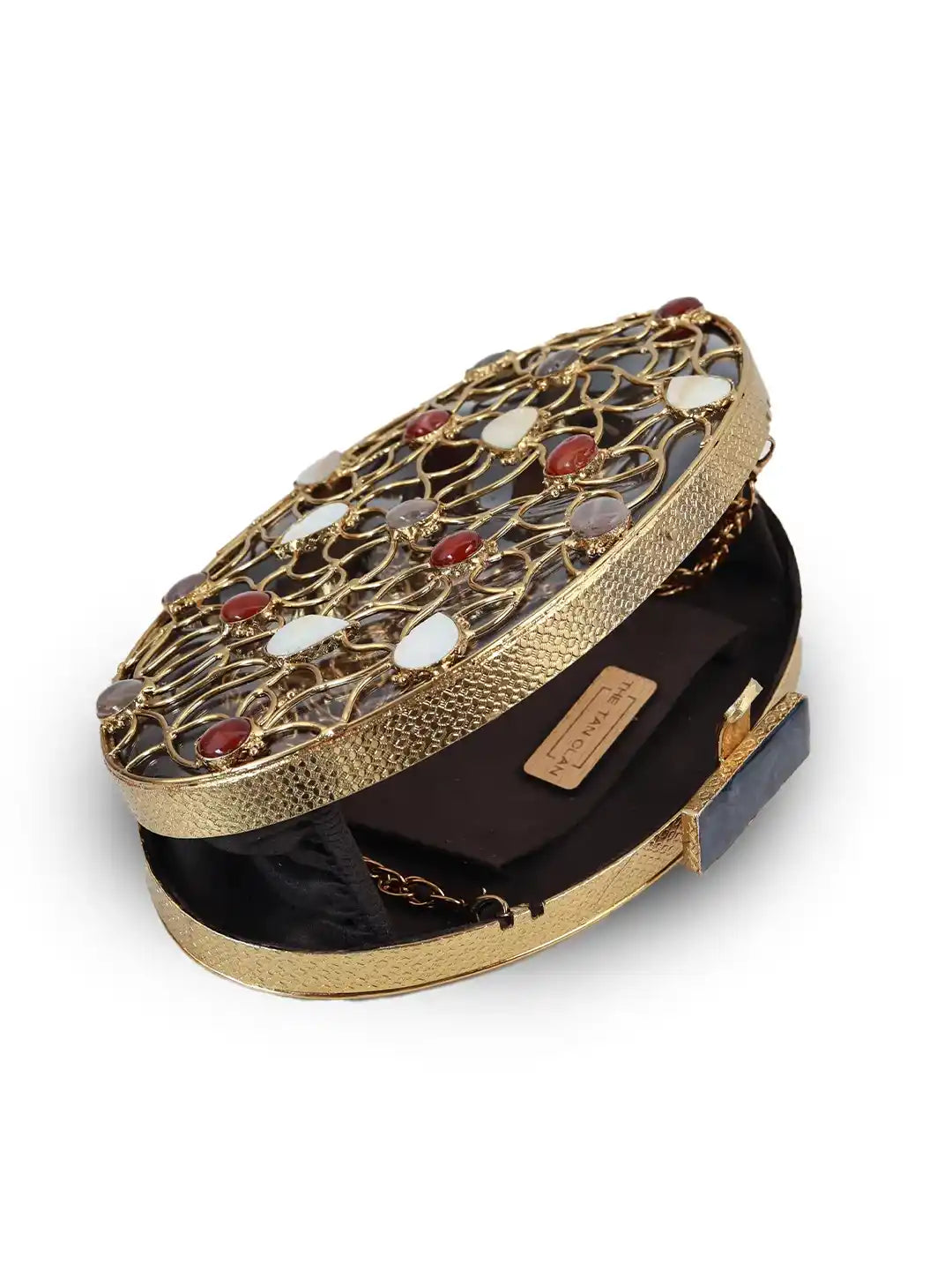 Gold clutch with gemstone accents on a white background