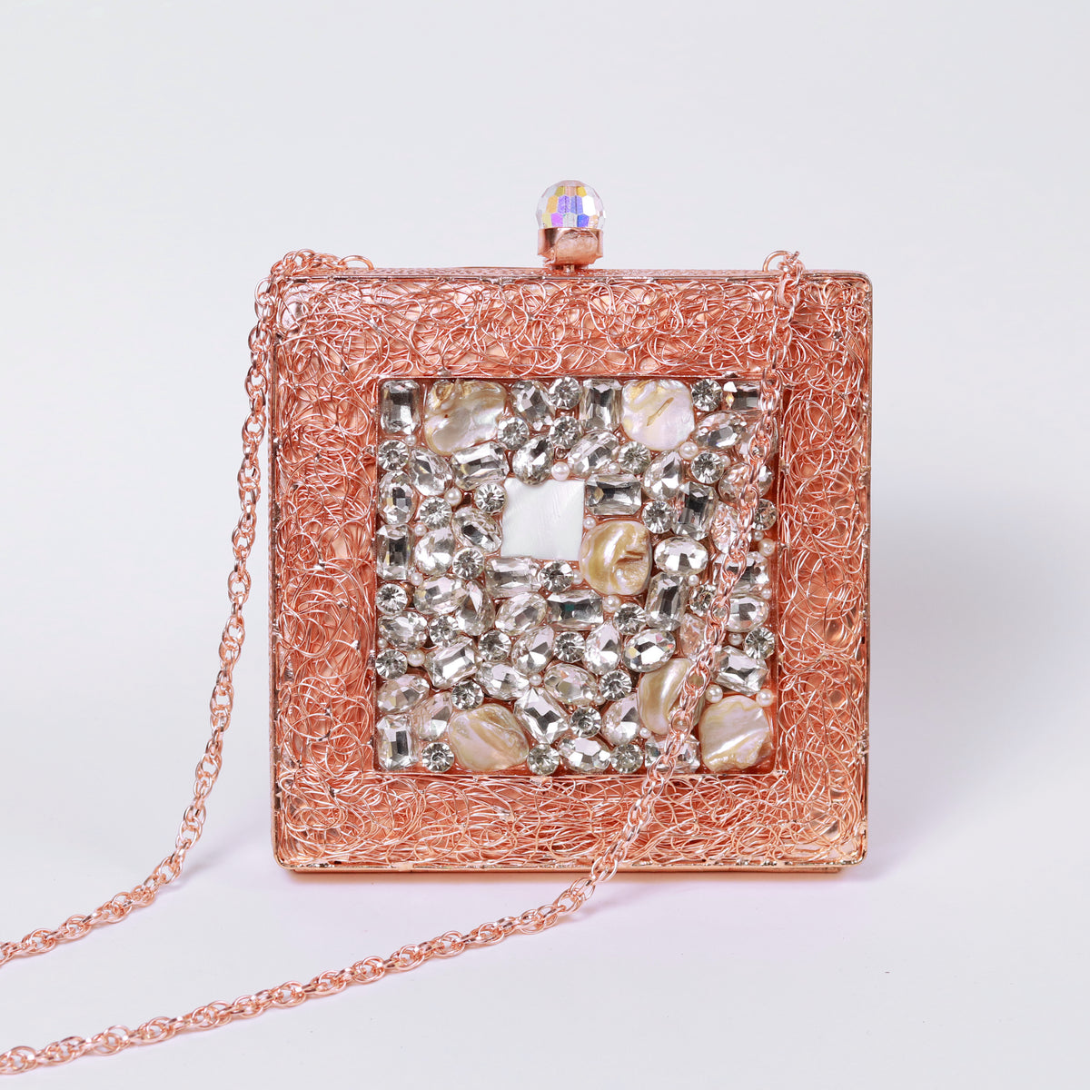 Rose gold embellished brass clutch bag with intricate detailing from The Tan Clan's Aafreen collection.