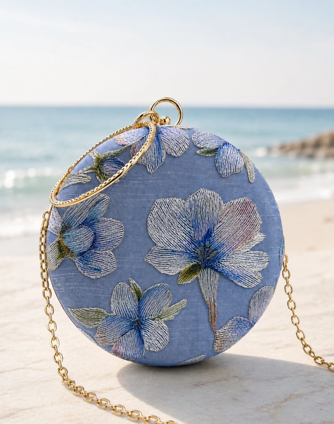 Blue embroidered clutch purse by The Tan Clan featuring floral designs, perfect for elegant occasions.