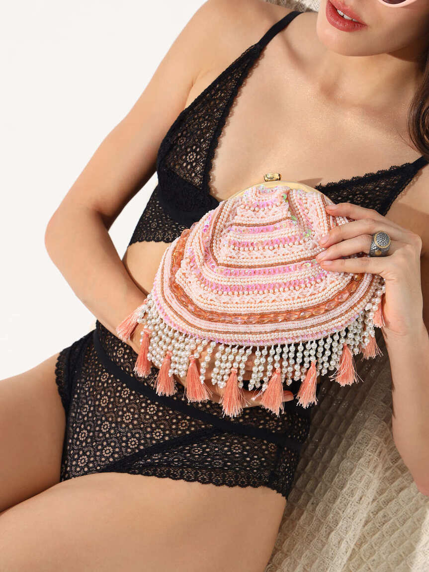 Pink Nora tasselled half moon batua bag by The Tan Clan with woven detailing and tassel accents.