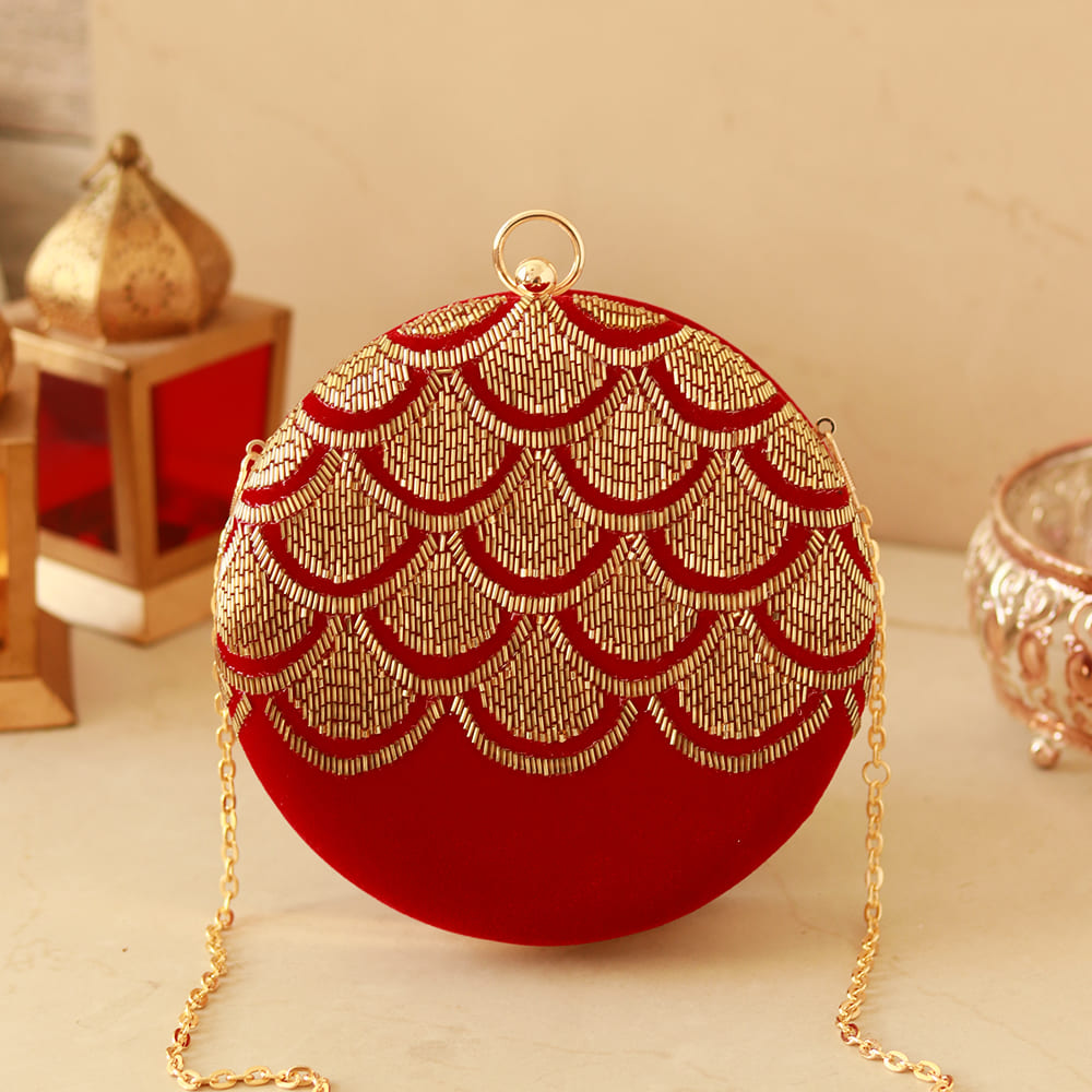 Red Rajwada hand-embroidered clutch bag from The Tan Clan with intricate traditional embroidery and a decorative clasp.