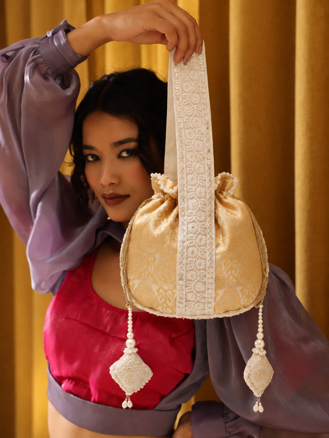 Yellow Ruhi Potli Bag with handle by The Tan Clan, featuring intricate embroidery and traditional design.