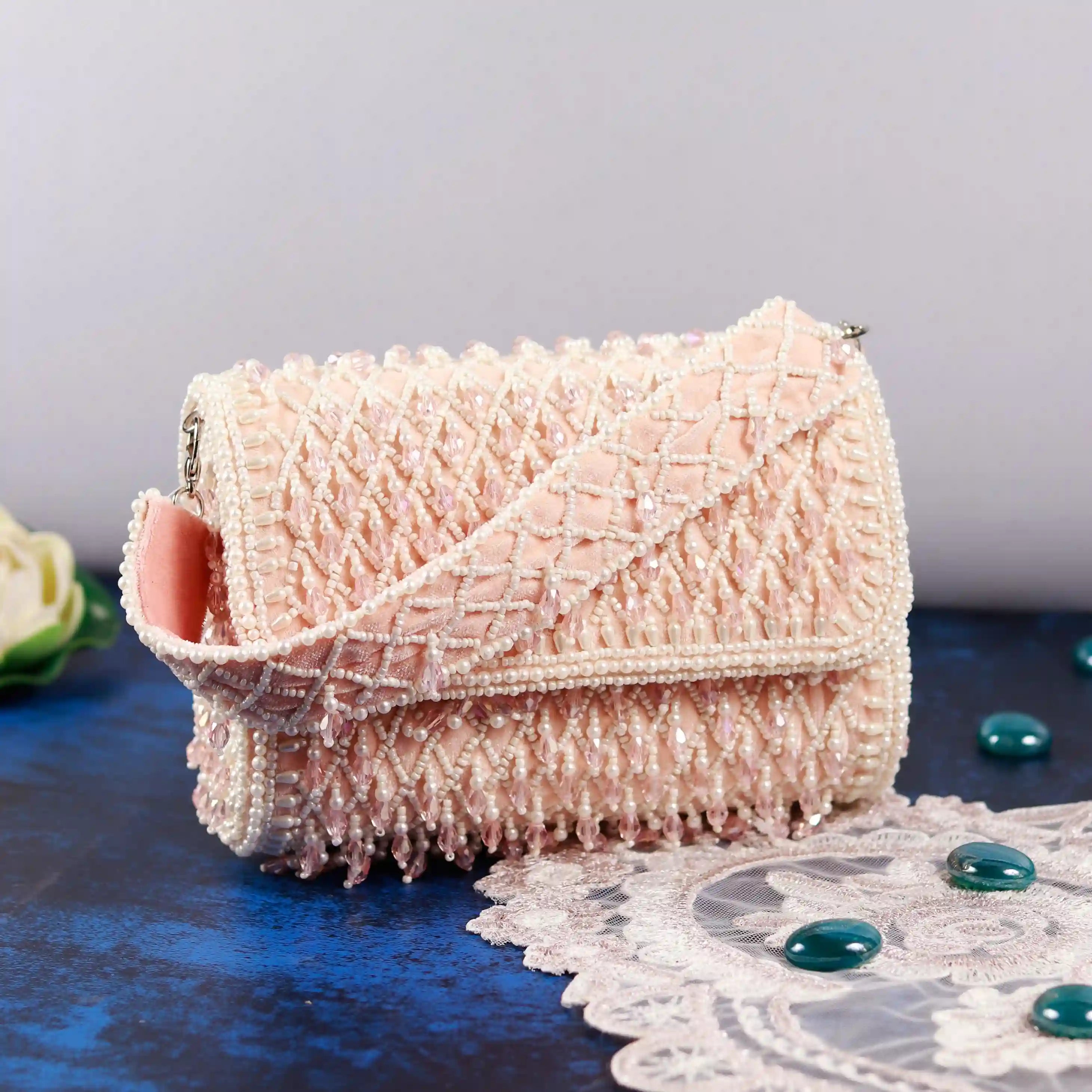 Blush flap-over bag with handle from The Tan Clan, showcasing a stylish design and functional shoulder strap.