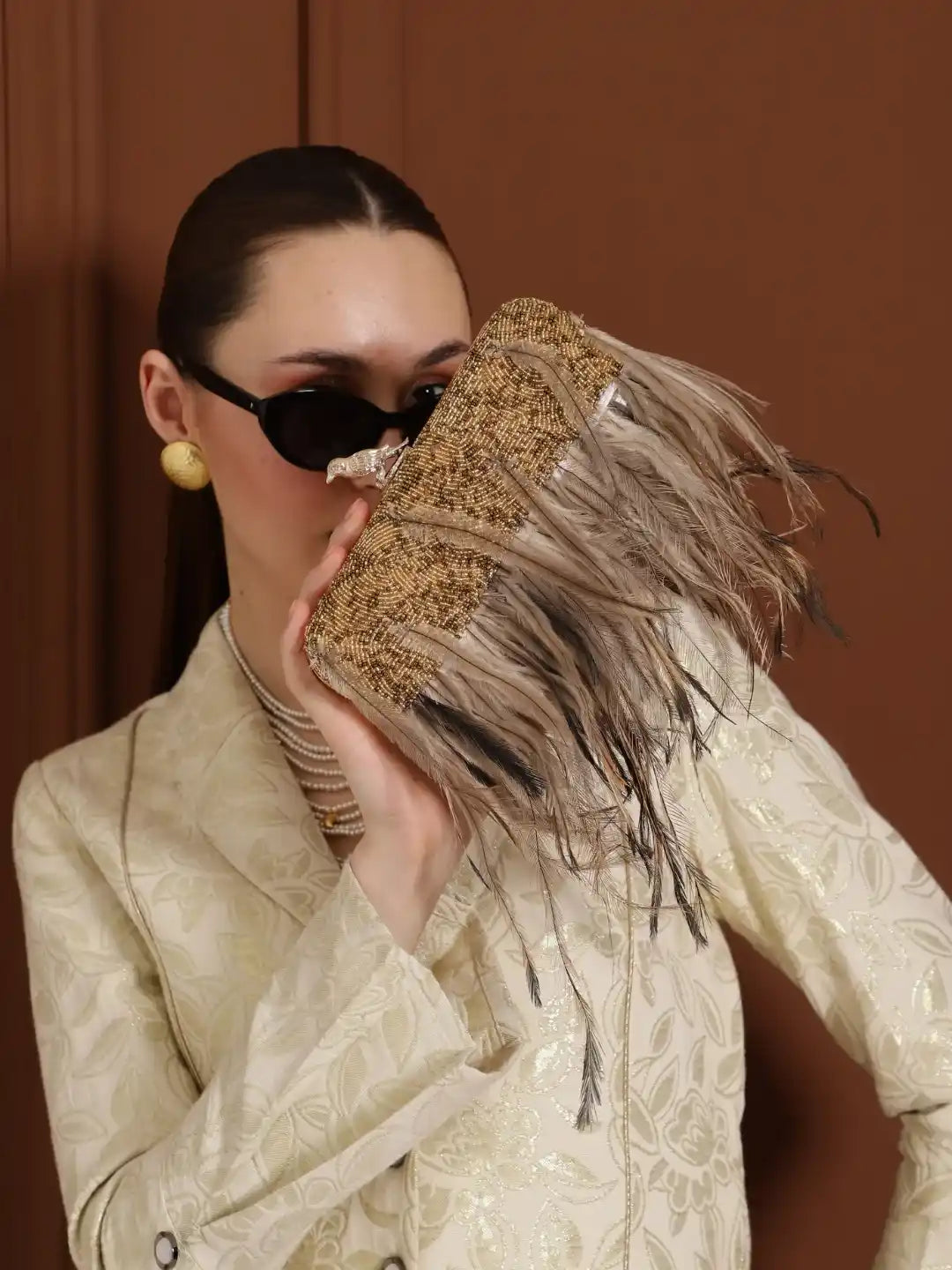 Dark gold hand-embroidered feather clutch by The Tan Clan featuring intricate embroidery and a sleek, elegant design.