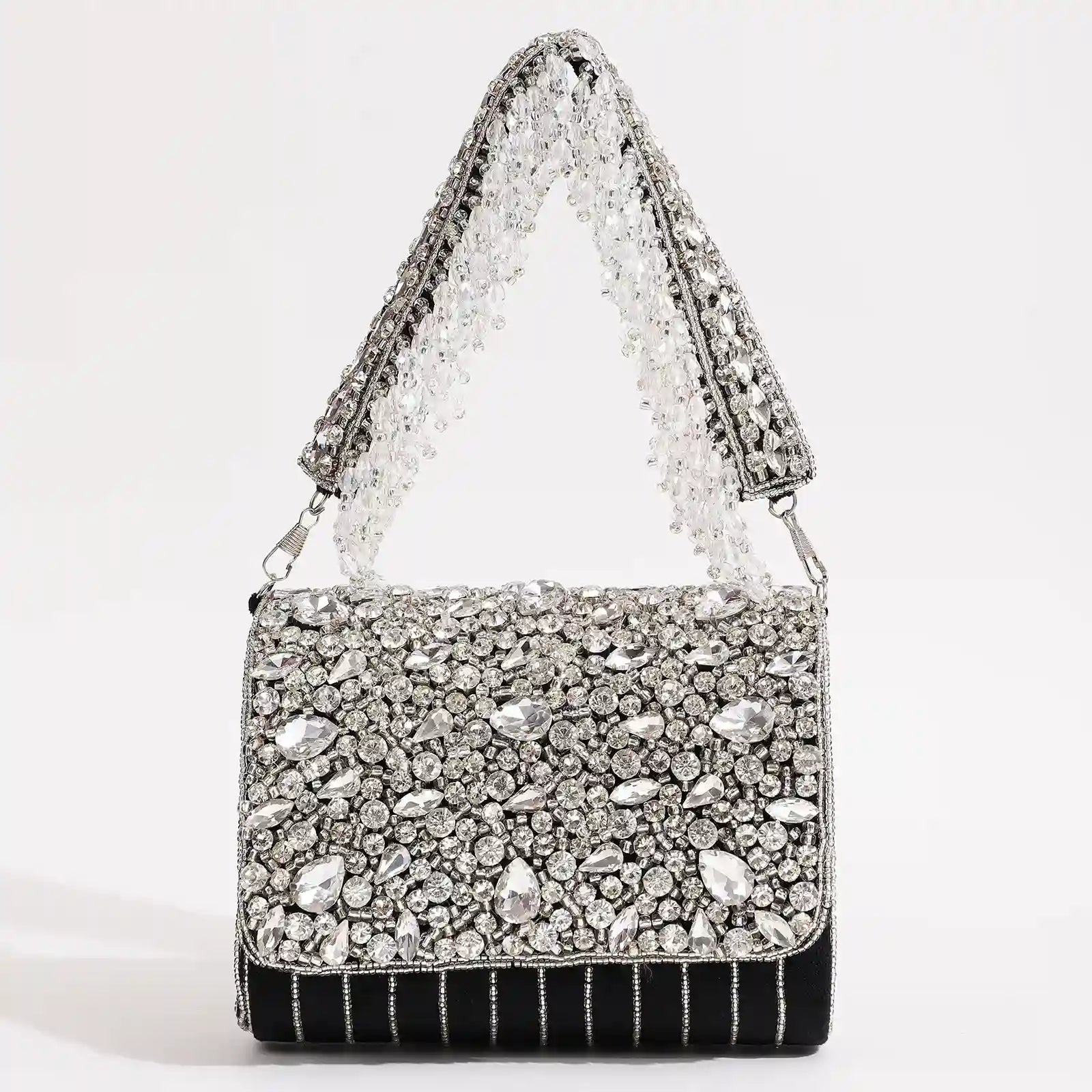 Black Grace embellished flap-over bag by The Tan Clan with decorative accents and a structured design.