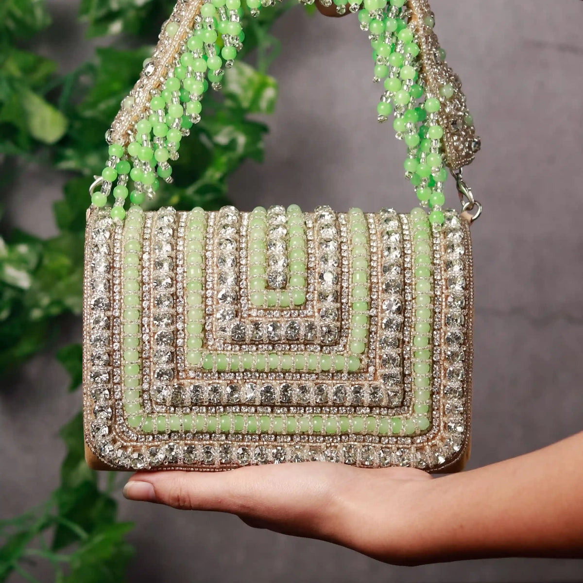 Nysa green embellished flap-over clutch bag by The Tan Clan, featuring intricate embellishments and a sleek design for elegant occasions.