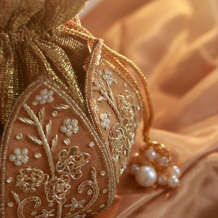 Pushp Zardozi embroidered mini lotus potli bag by The Tan Clan with golden lotus design and traditional embroidery details.