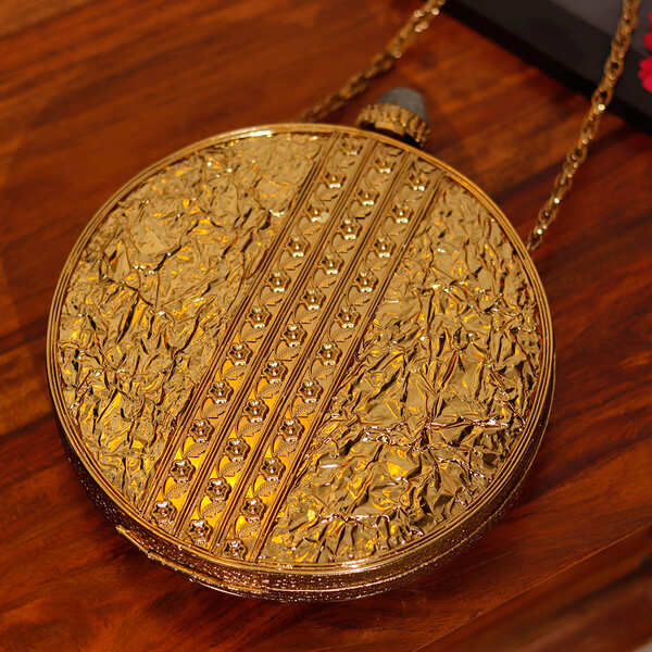Elegant brass clutch with intricate embellishments from The Tan Clan, featuring detailed craftsmanship and a stylish design.