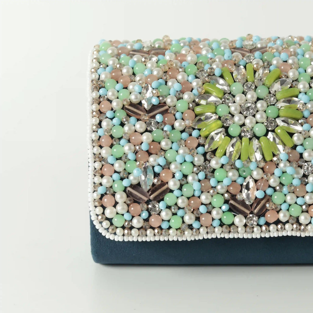 Rainbow embellished flap-over clutch bag by The Tan Clan, featuring colorful rainbow details and a sleek design.