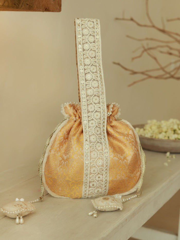 Yellow Ruhi Potli bag with handle from The Tan Clan, featuring traditional design and tassel details.