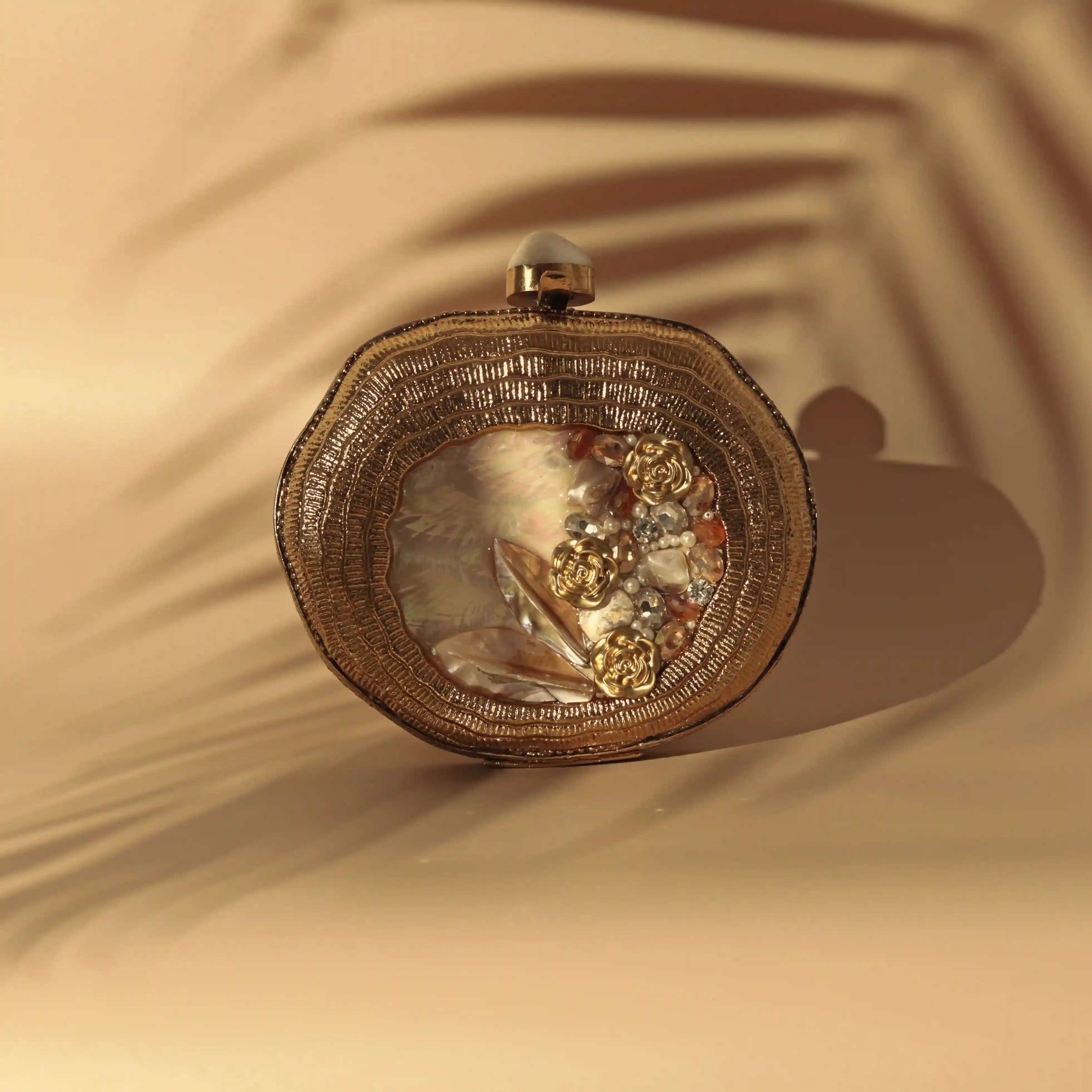 Elegant Sana embellished mother of pearl clutch by The Tan Clan, featuring intricate design and polished pearl accents.