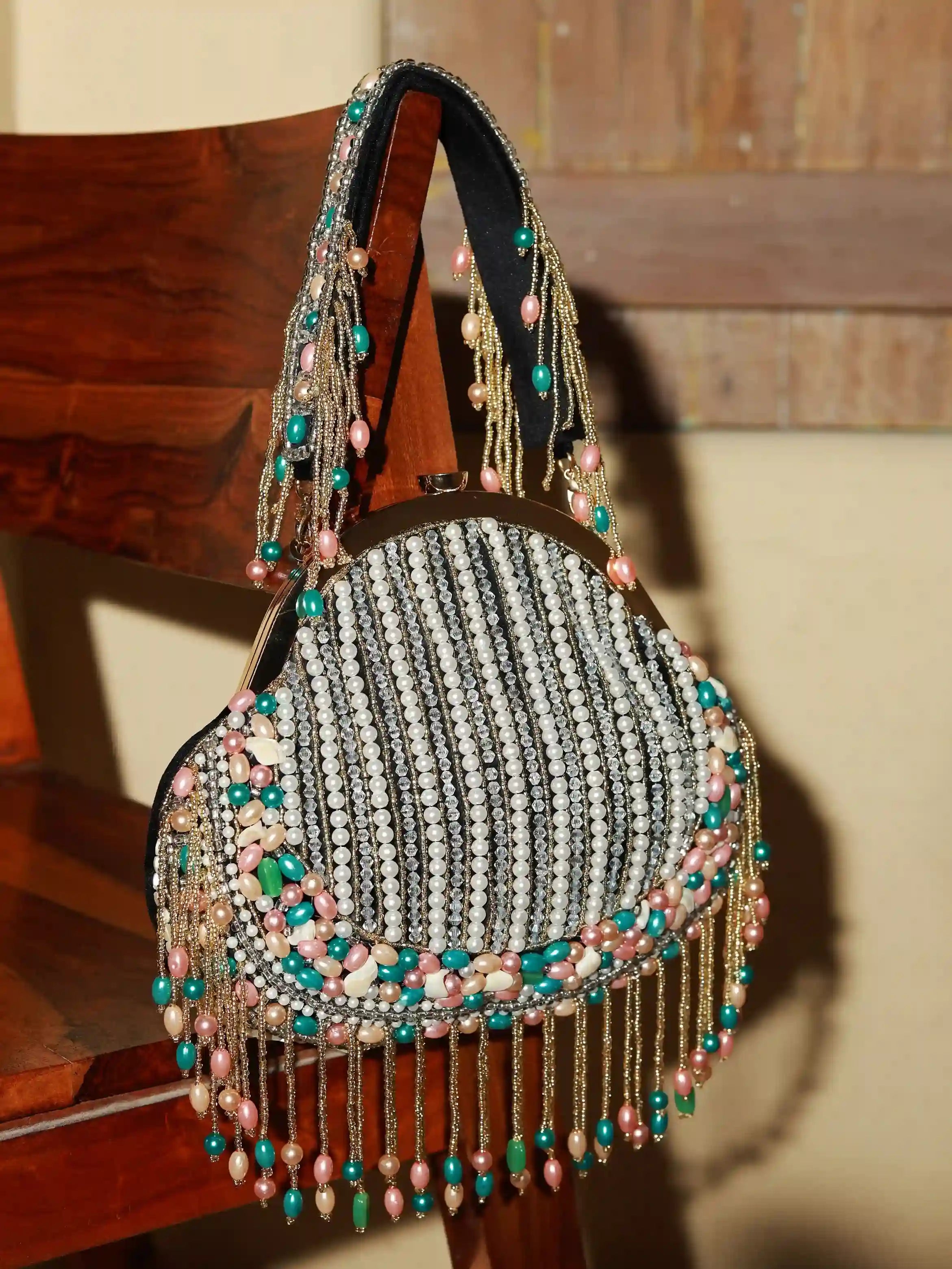 Sona Pearl Tasselled Batua by The Tan Clan featuring pearl embellishments, tassels, and a detachable handle for traditional elegance.