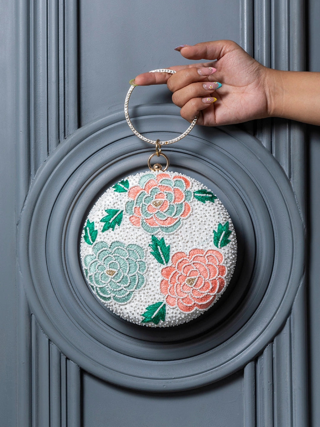Zahra round floral hand-embroidered clutch by The Tan Clan with intricate floral embroidery and a round shape.