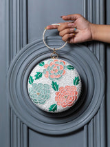 Zahra round floral hand-embroidered clutch by The Tan Clan with intricate floral embroidery and a round shape.