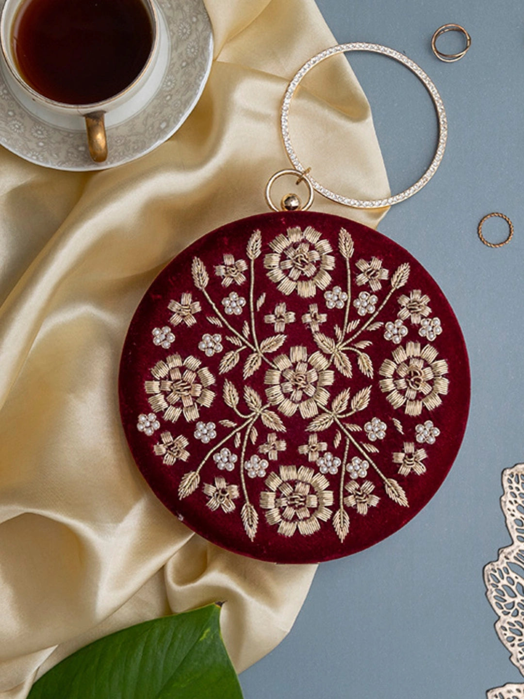Maroon hand-embroidered clutch bag by The Tan Clan with intricate embroidery and a sleek design for elegant occasions.