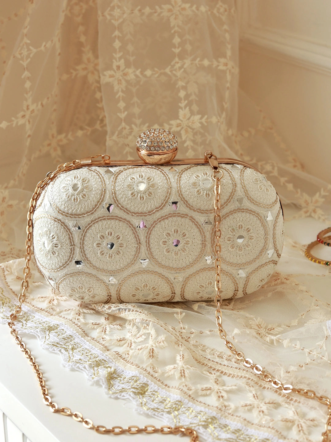 Inaara white oval clutch by The Tan Clan featuring a sleek design and elegant oval shape, perfect for evening occasions.