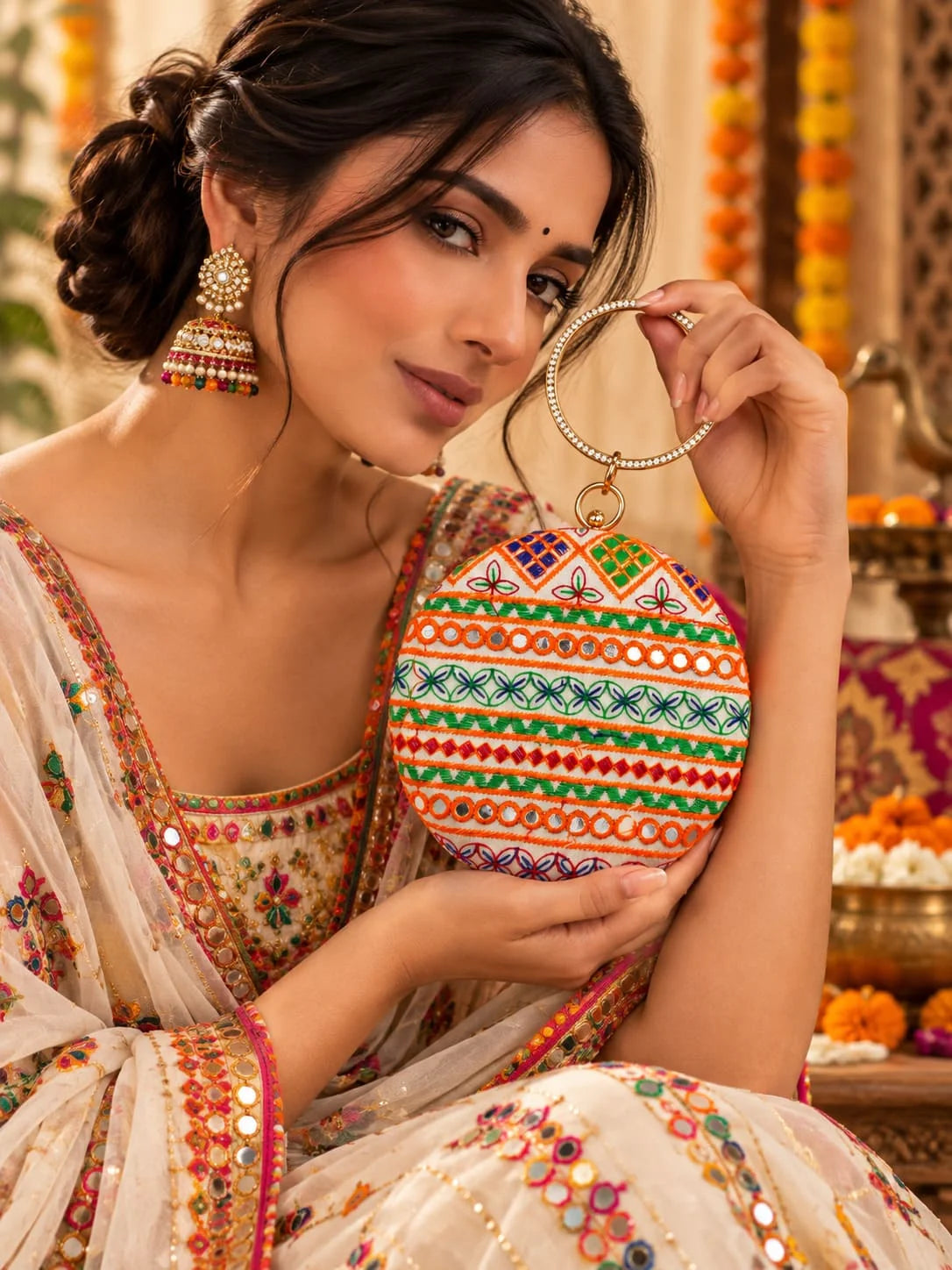 Multicolor round clutch bag from THE TAN CLAN with vibrant circular patterns and a sleek design.