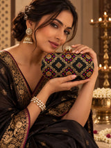 Black oval clutch bag from THE TAN CLAN with a sleek, textured finish and compact design for stylish carrying.