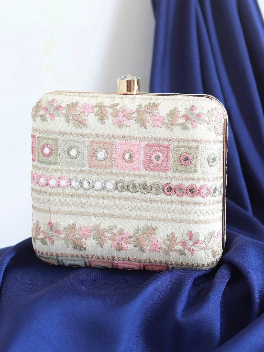 Pink floral box clutch by The Tan Clan featuring intricate embroidery and a sleek rectangular shape with a metallic clasp.