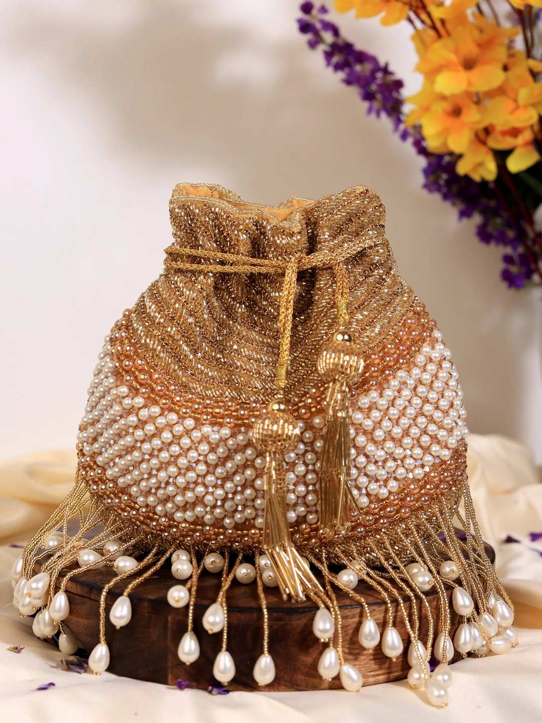 The Tan Clan Dua Gold Pearl potli bag with shimmering gold finish and pearl embellishments