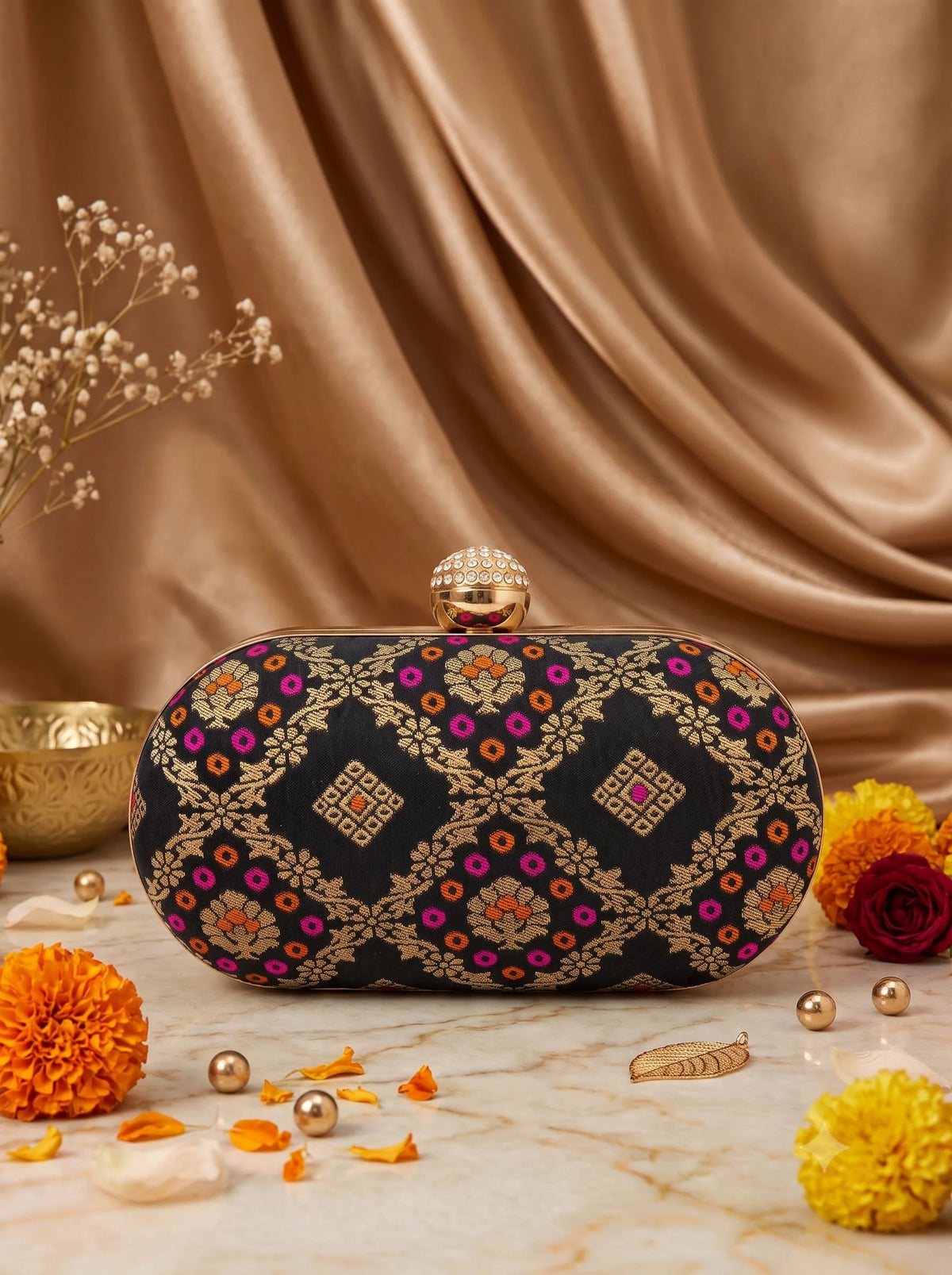Black oval clutch bag by THE TAN CLAN featuring a sleek, smooth surface and compact design suitable for evening occasions.