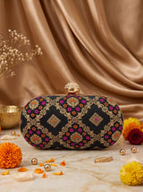 Black oval clutch bag by THE TAN CLAN featuring a sleek, smooth surface and compact design suitable for evening occasions.
