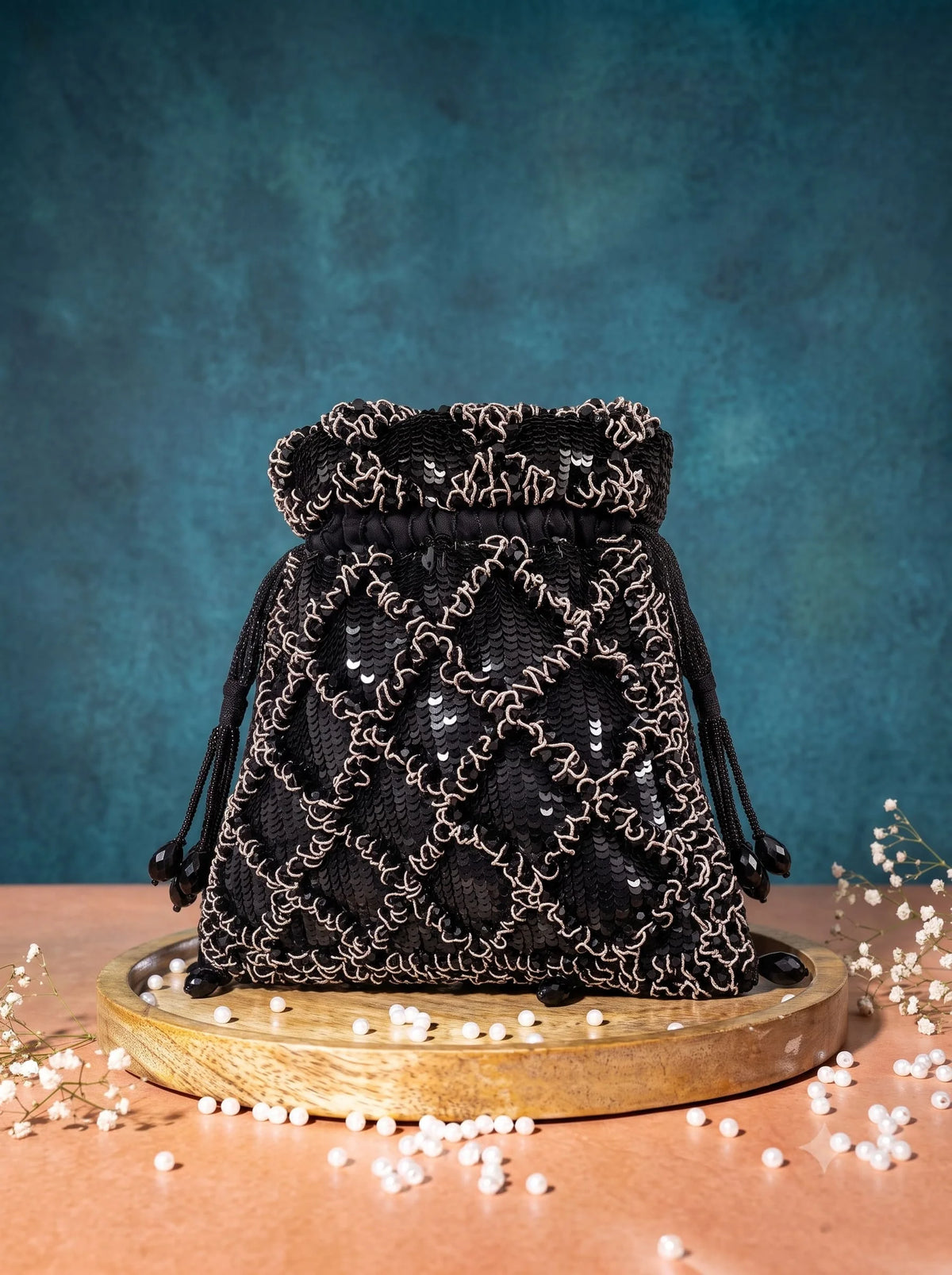 Black sequined tasselled potli bag with intricate embroidery, designed by THE TAN CLAN, perfect for festive occasions.