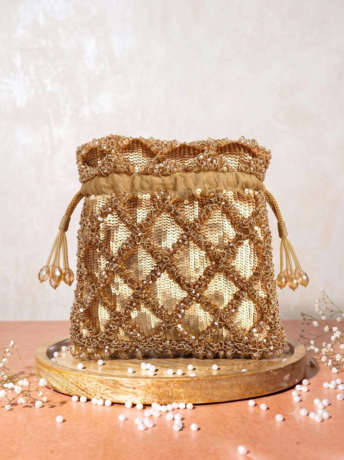 Gold sequined tasselled potli bag from THE TAN CLAN with intricate embroidery and traditional design.