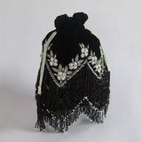 Black tassel potli bag with handle from The Tan Clan, featuring decorative tassels and traditional design.
