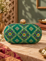 Light green oval clutch bag from THE TAN CLAN with a smooth finish and compact design, perfect for stylish accessories.