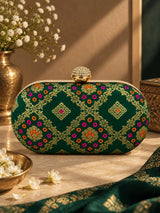 Dark green oval clutch bag from THE TAN CLAN with a sleek, stylish design and compact shape.