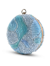 Aqua blue round clutch bag with a textured surface, featuring a sleek design and a gold clasp, by The Tan Clan.