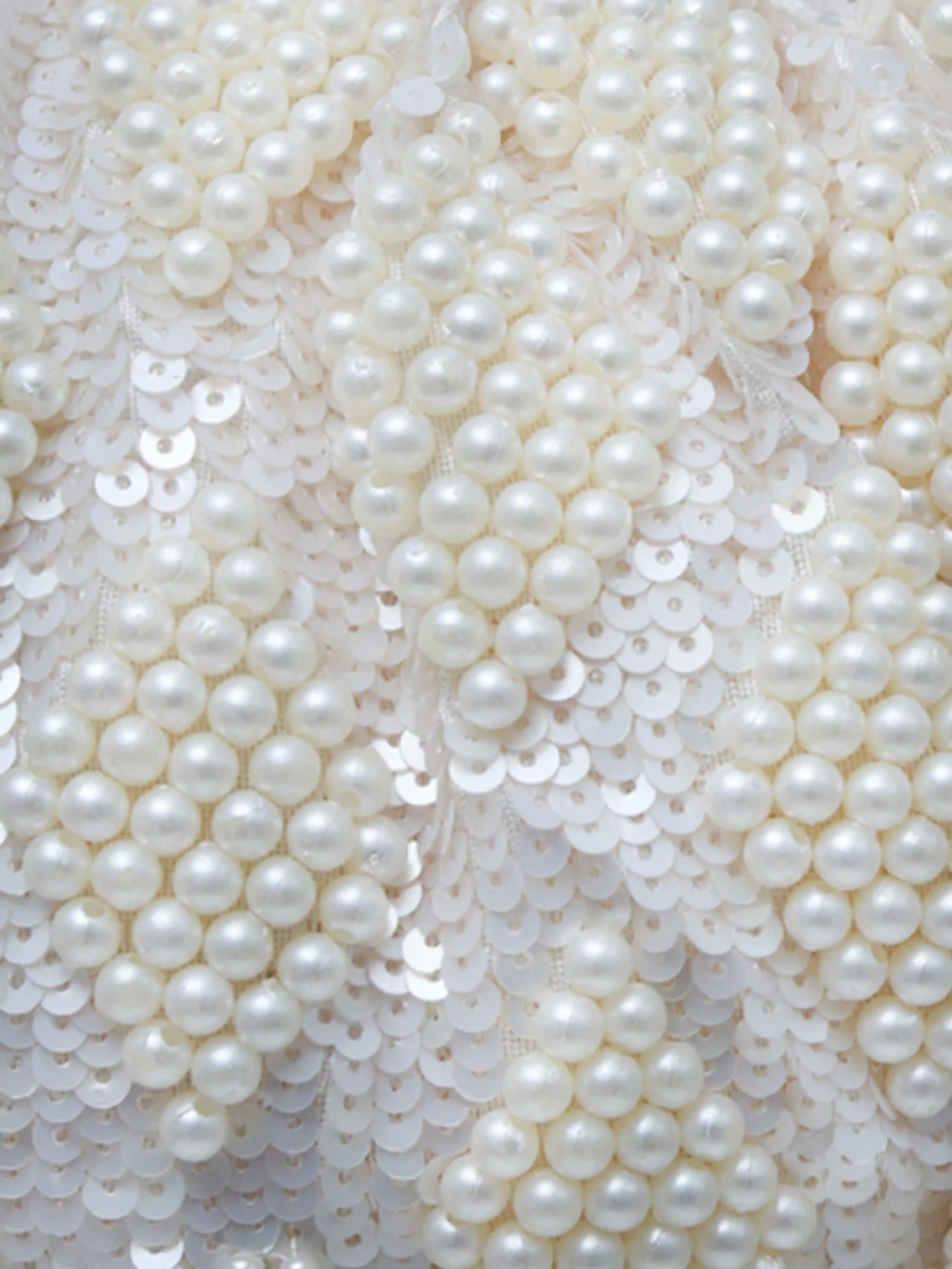 Tara Pearl Tasselled Batua bag with detachable handle from The Tan Clan, featuring pearl embellishments and decorative tassels.