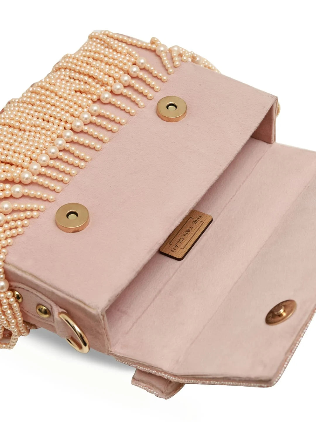 Pink handbag with pearl fringe and gold accents on a white background