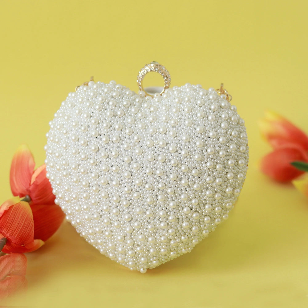 Ulfat All White Pearl Hand Embroidered Heart Clutch by The Tan Clan, featuring intricate pearl embroidery and a heart-shaped design.