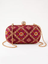 Red oval clutch purse by THE TAN CLAN featuring a smooth leather finish and compact design for stylish occasions.