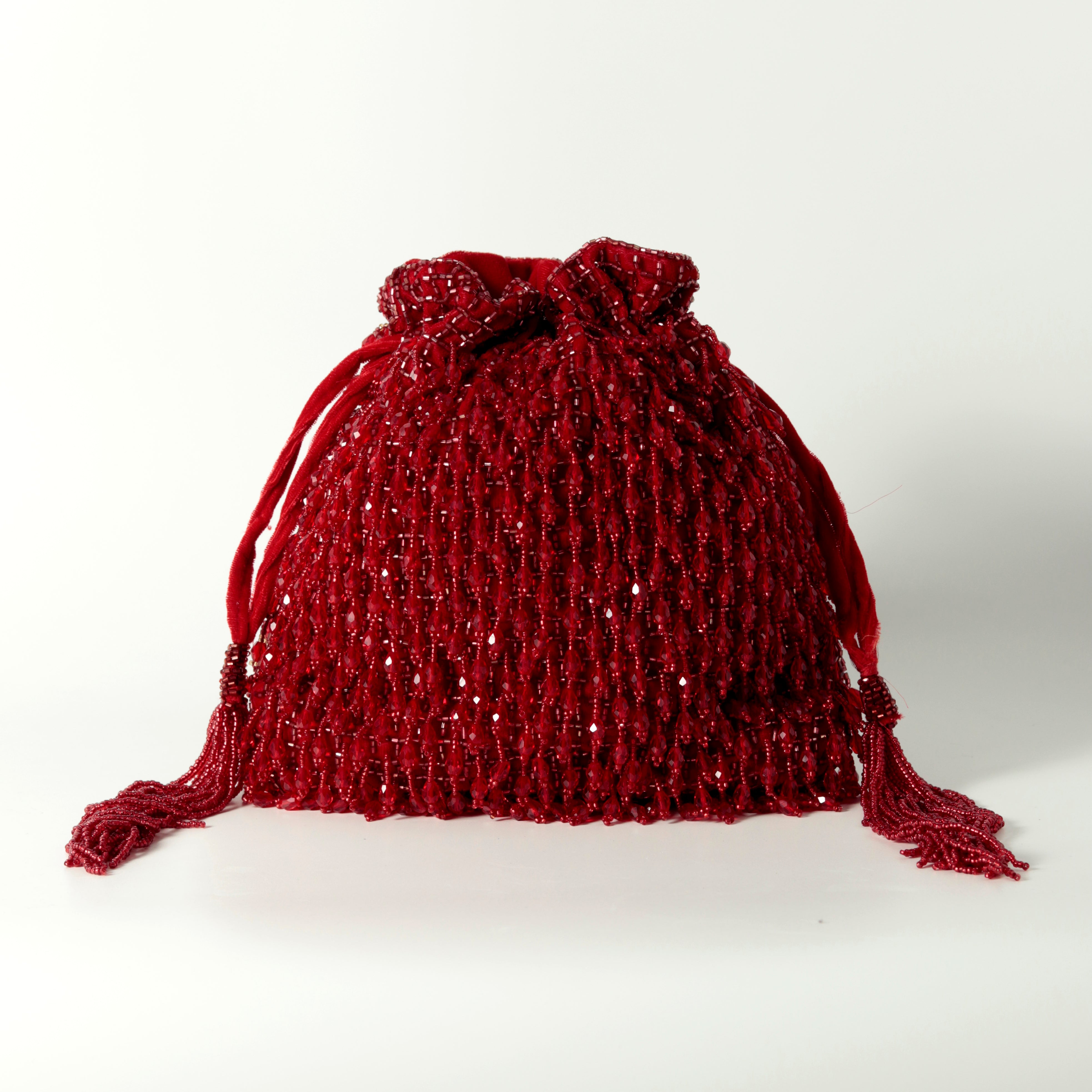 Red Rosa Potli bag with handle from The Tan Clan, showcasing its traditional drawstring design and vibrant color.