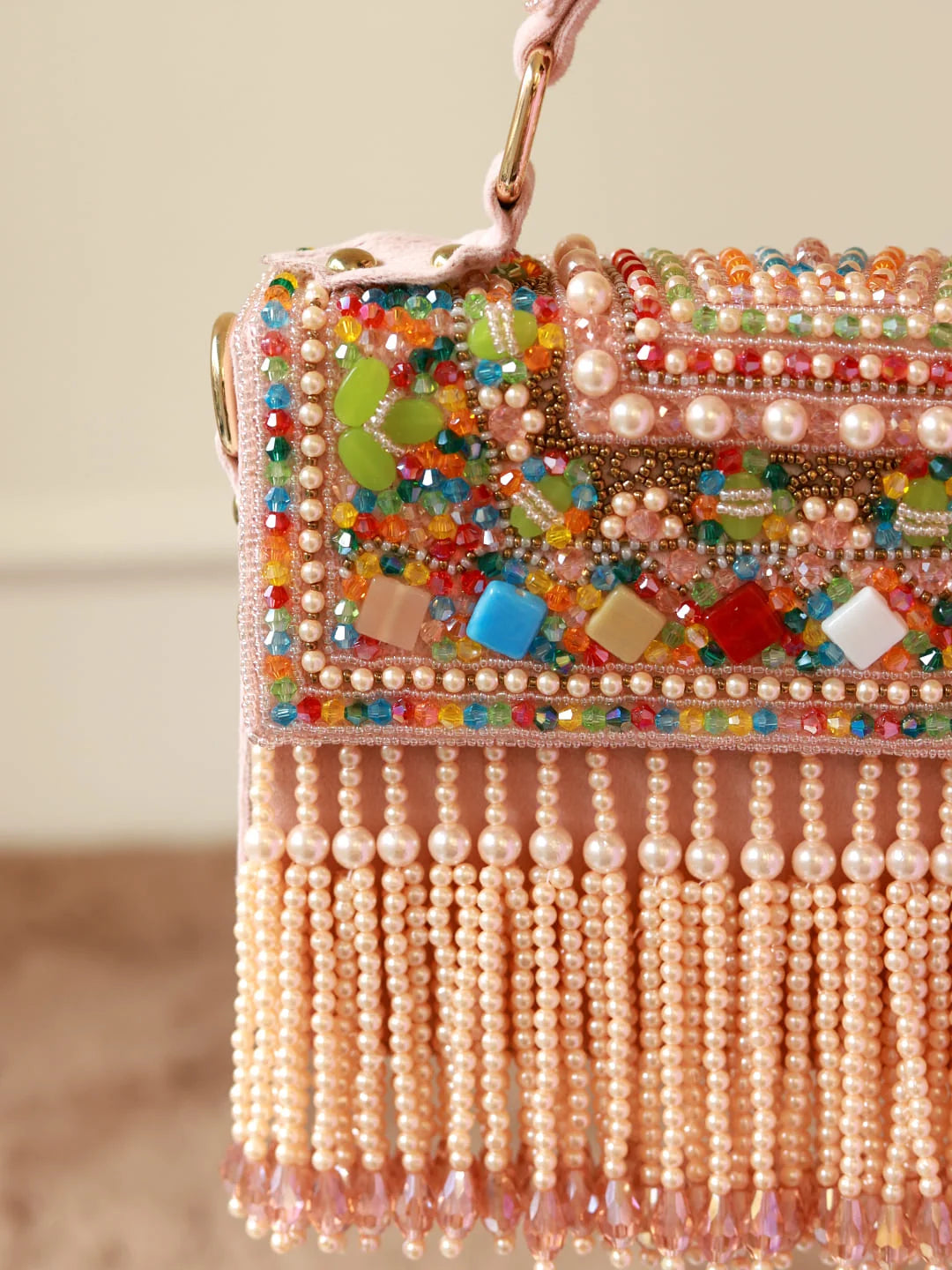 Colorful beaded handbag with fringes on a neutral background