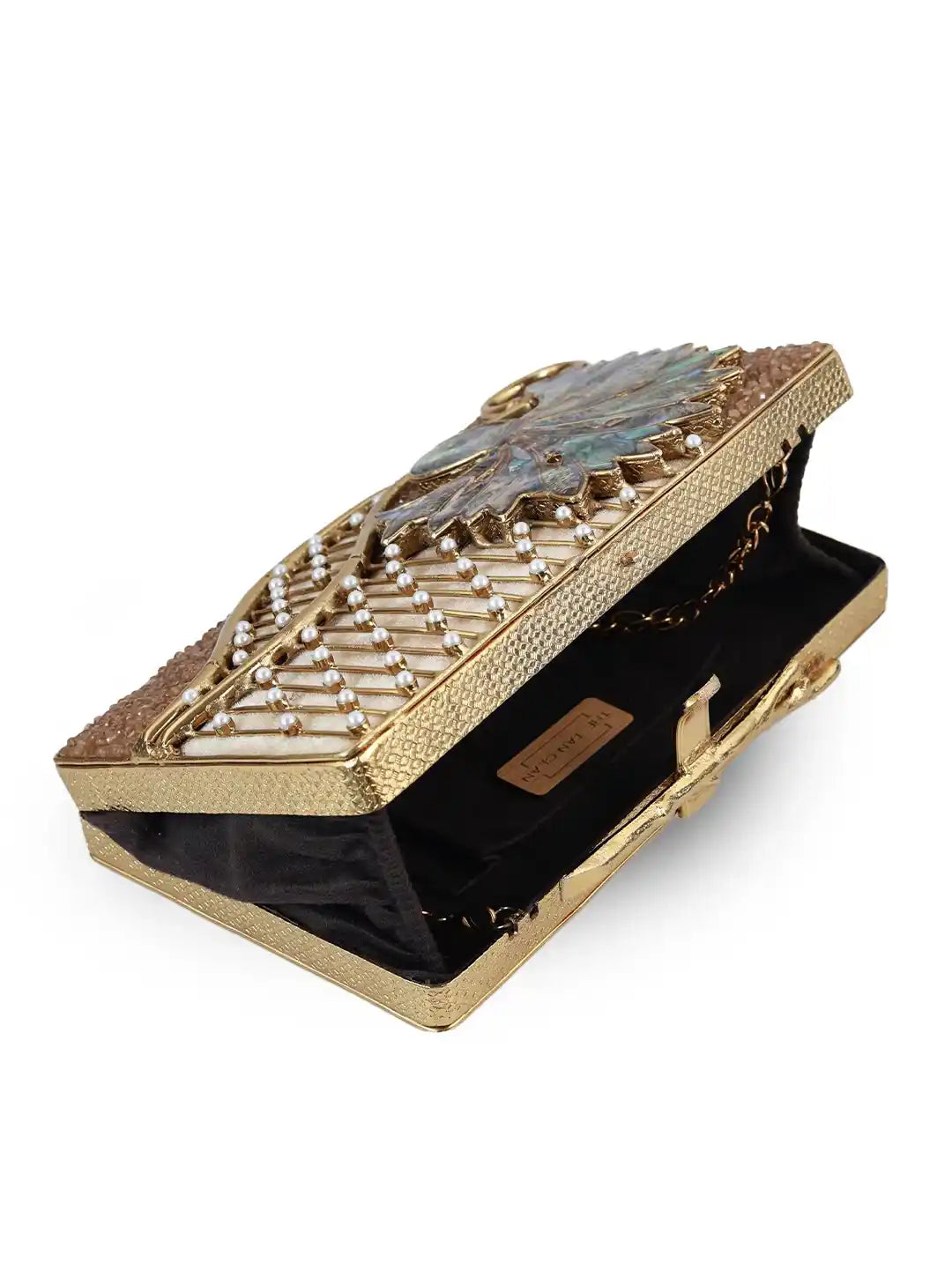 Gold clutch with intricate design on a white background