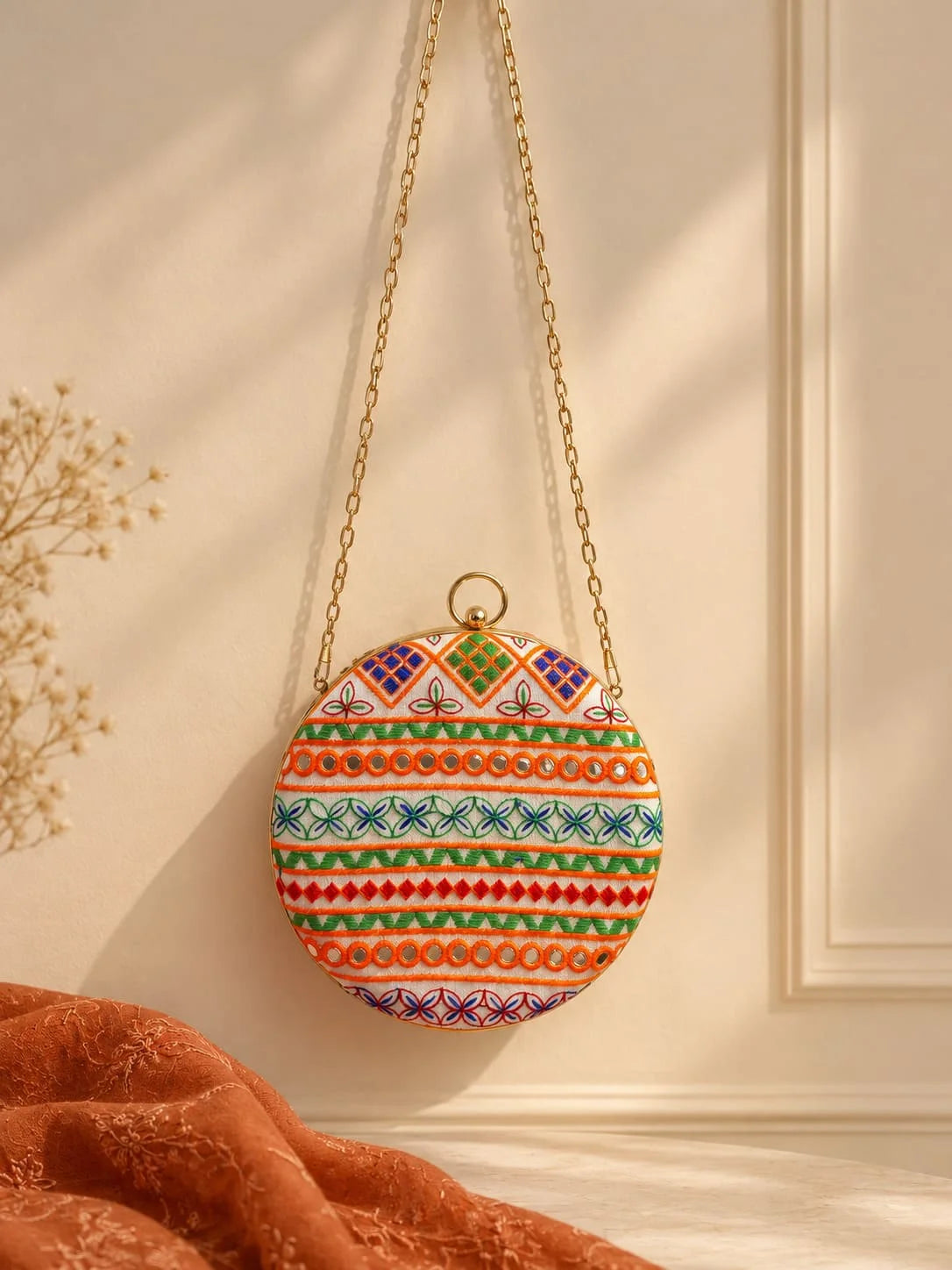 Multicolor round clutch bag by THE TAN CLAN featuring vibrant geometric patterns and a compact, stylish design.