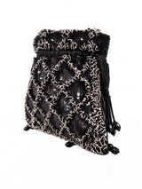 Black sequined tasselled potli bag by THE TAN CLAN featuring intricate beadwork and a decorative tassel closure.