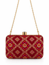 Red Mahi box clutch by THE TAN CLAN, featuring a sleek rectangular design with subtle texture and elegant gold accents.