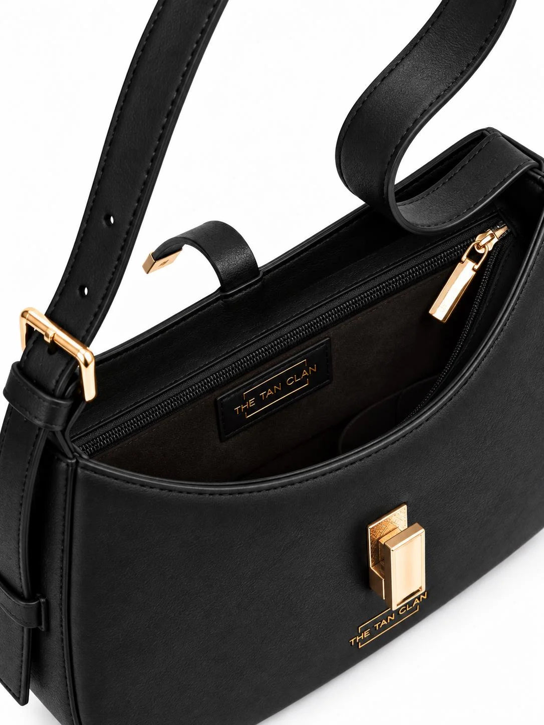 Close-up of THE TAN CLAN Dune black textured leather baguette shoulder bag interior with adjustable strap detail.