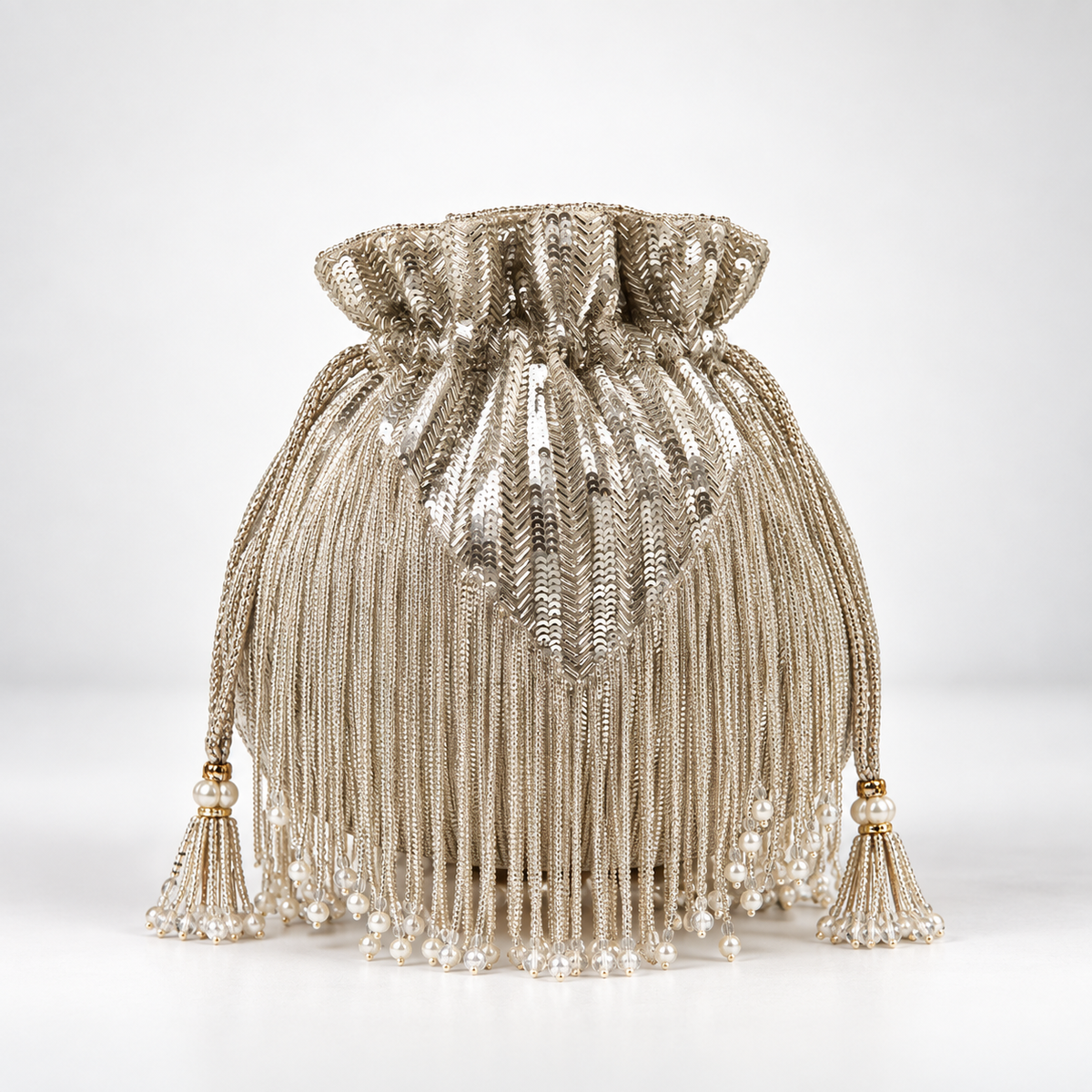 Silver Twinkle Heavy Tassle Potli bag with handle by The Tan Clan, featuring intricate embroidery and decorative tassels.