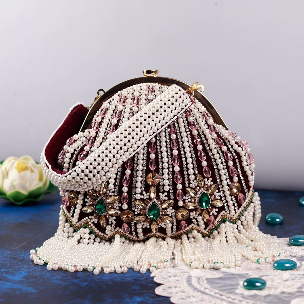 Maroon Frida Batua bag with detachable handle by The Tan Clan, showcasing its stylish design and versatile carrying options.
