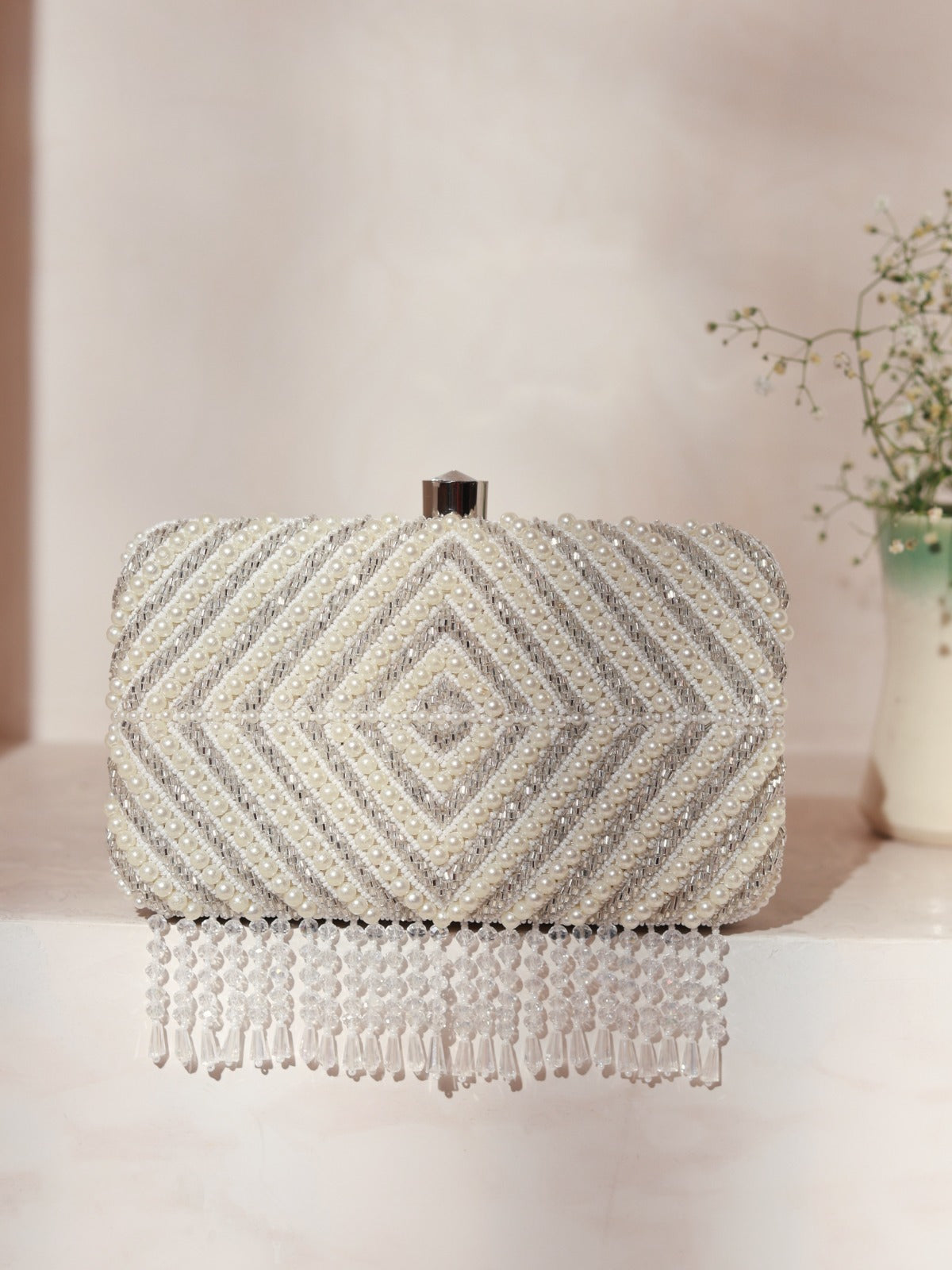 Silver hand-embroidered clutch with pearl details from The Tan Clan, showcasing intricate craftsmanship and elegant design.