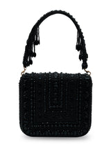 Black flap-over bag from The Tan Clan's Megan collection, featuring a sleek design and structured silhouette.