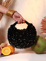 Black Jia Half Moon Batua Bag by The Tan Clan featuring a compact, stylish design with a curved shape and adjustable strap.