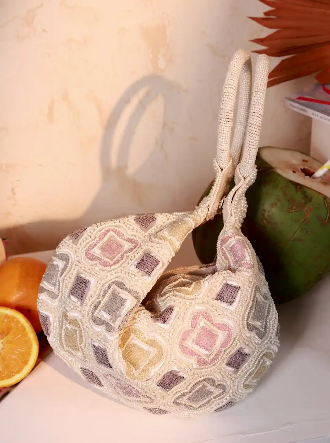 Luna White Half Moon Bag by The Tan Clan Batua Bags, featuring a sleek white half moon-shaped design with a strap for carrying.
