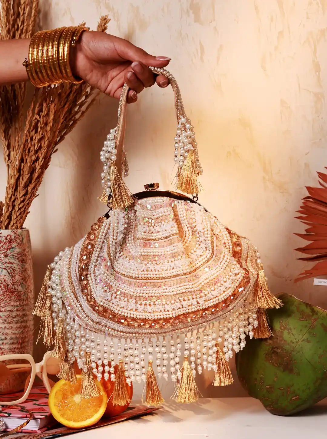 Tan Tan Clan Nora tasselled half moon Batua bag with decorative tassels and compact design, perfect for casual and festive occasions.